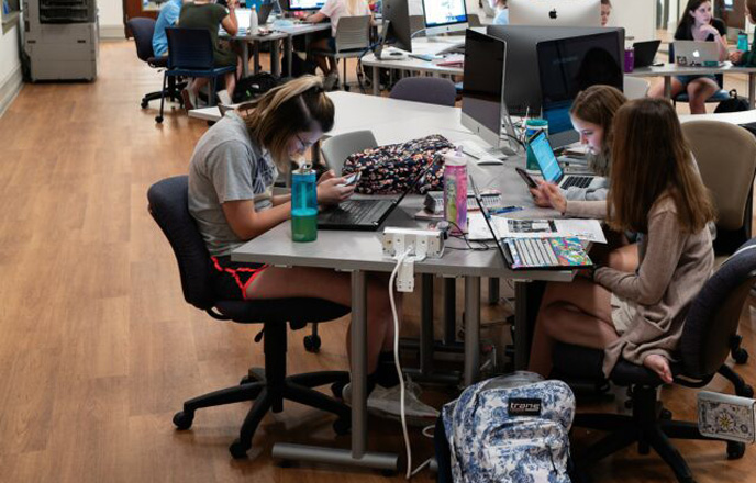 Students working on computers around a table.